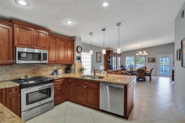 kitchen featuring pendant lighting, lofted ceiling, sink, kitchen peninsula, and stainless steel appliances