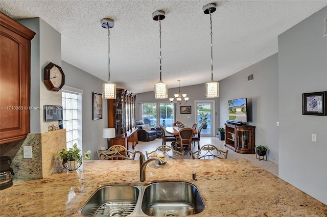 kitchen featuring tasteful backsplash, a wealth of natural light, sink, pendant lighting, and lofted ceiling