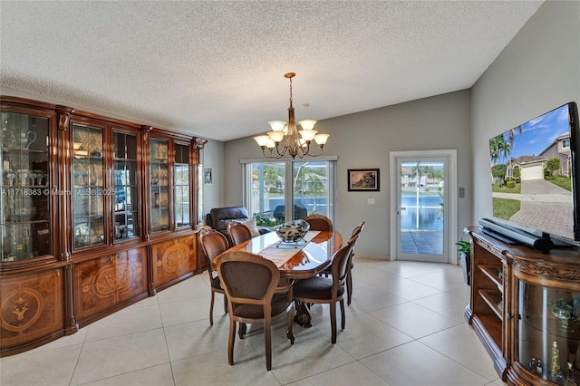 dining room featuring light tile patterned floors, a textured ceiling, lofted ceiling, and a notable chandelier