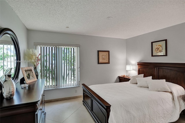 bedroom with light tile patterned floors, a textured ceiling, and multiple windows