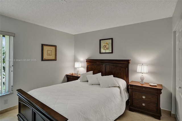 bedroom with multiple windows, light tile patterned floors, and a textured ceiling