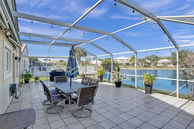 view of patio / terrace featuring a water view and a lanai