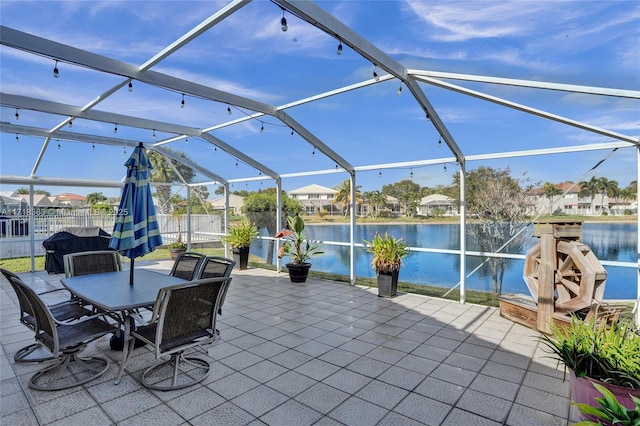 view of patio / terrace featuring a lanai and a water view