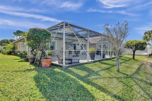 rear view of property with glass enclosure and a lawn