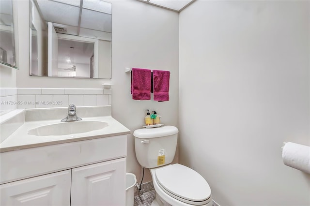 bathroom with tasteful backsplash, vanity, and toilet