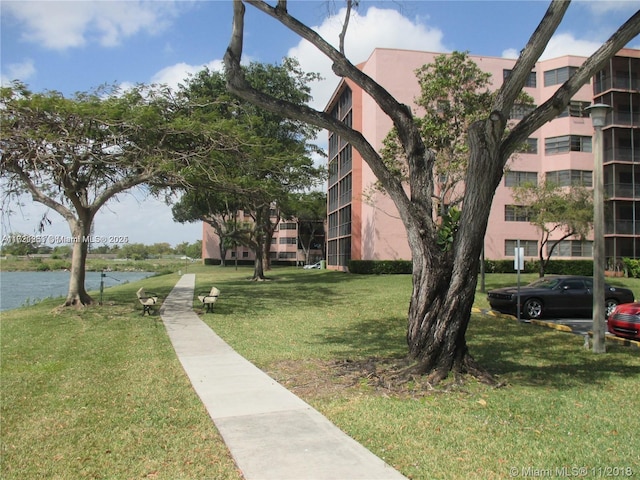 surrounding community featuring a water view and a lawn