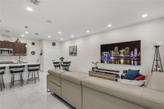 living room with marble finish floor, visible vents, and recessed lighting