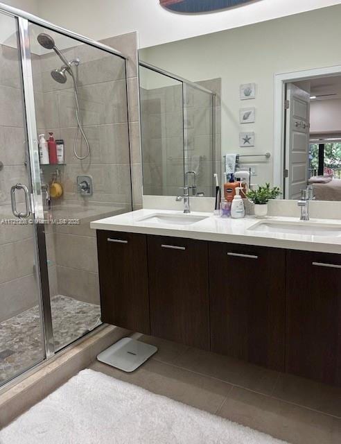 bathroom with tile patterned flooring, a shower with shower door, and vanity