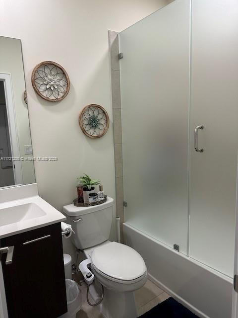 bathroom with toilet, vanity, walk in shower, and tile patterned flooring