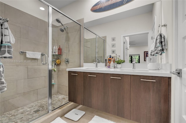 full bathroom with a stall shower, a sink, and double vanity