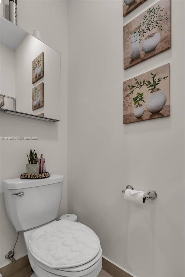 bathroom with baseboards and toilet