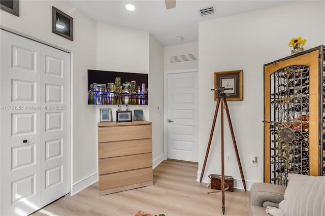 living area featuring baseboards, visible vents, and light wood finished floors