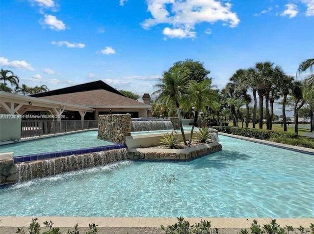 view of swimming pool with pool water feature