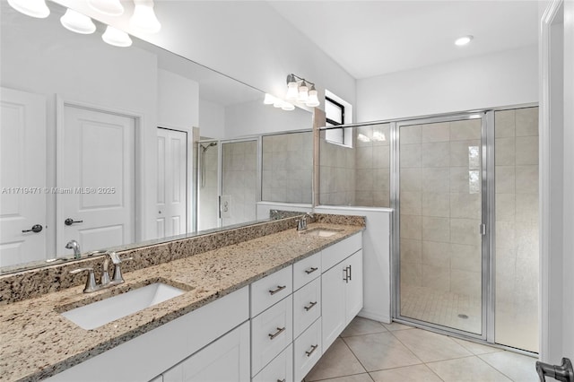 bathroom featuring a shower with door, vanity, and tile patterned flooring