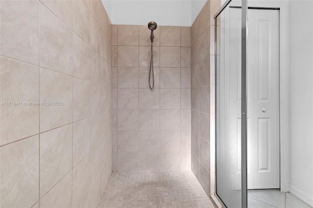 bathroom with tiled shower and tile patterned floors