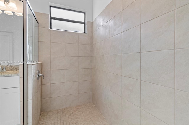 bathroom featuring vanity and tiled shower