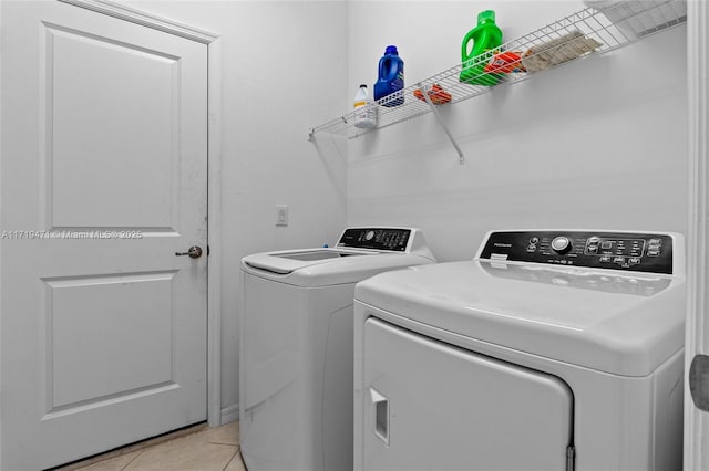 clothes washing area with light tile patterned floors and independent washer and dryer