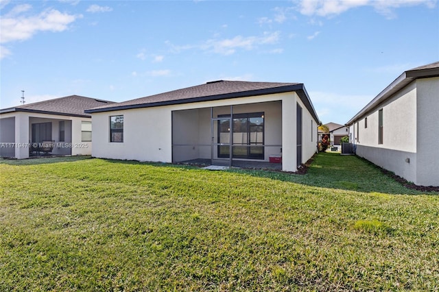 rear view of property with a yard and a sunroom