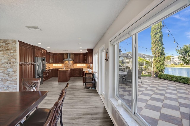 dining room featuring a textured ceiling and a water view