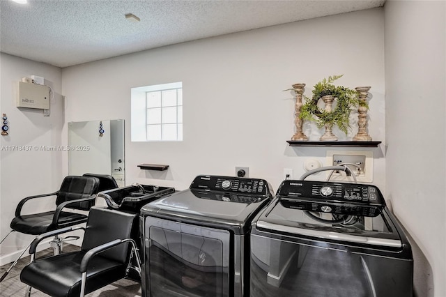 laundry area with washing machine and dryer and a textured ceiling