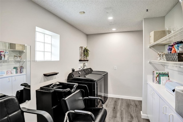 interior space with light wood-type flooring, a textured ceiling, and washing machine and dryer