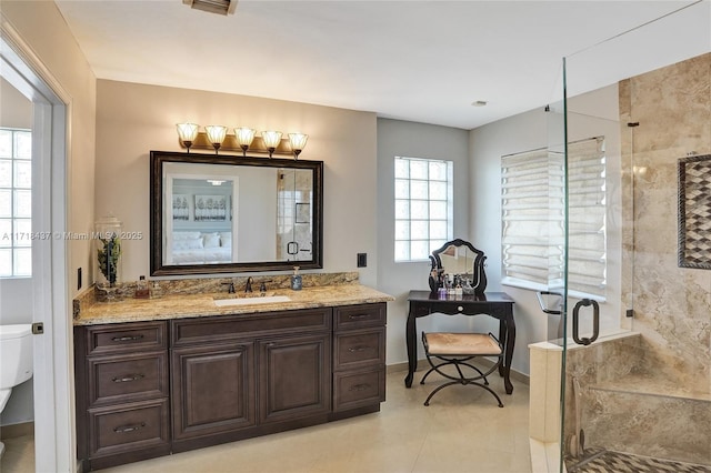 bathroom with vanity, toilet, and a shower with door