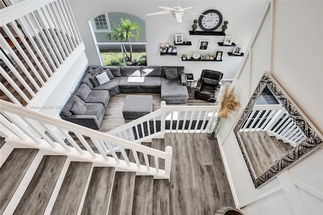 interior space with hardwood / wood-style flooring, ceiling fan, and a high ceiling