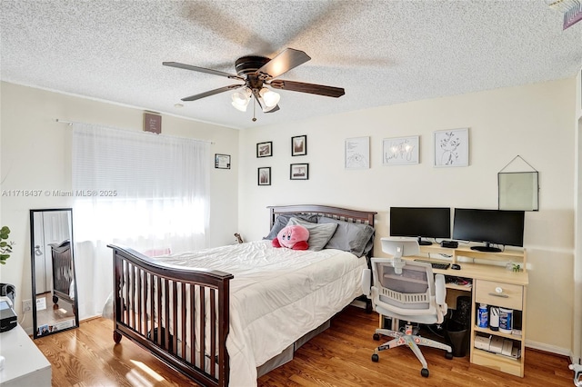 bedroom featuring hardwood / wood-style floors, a textured ceiling, and ceiling fan