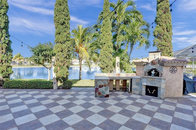 view of patio / terrace with a water view and an outdoor stone fireplace