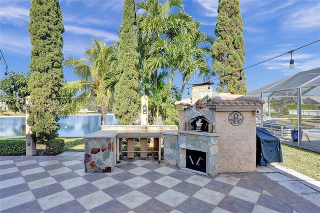 view of patio / terrace with area for grilling, a lanai, and a water view