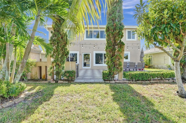 view of front of house with a patio area and a front yard