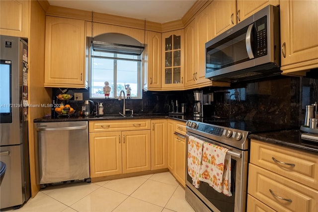 kitchen featuring light tile patterned flooring, sink, appliances with stainless steel finishes, and tasteful backsplash