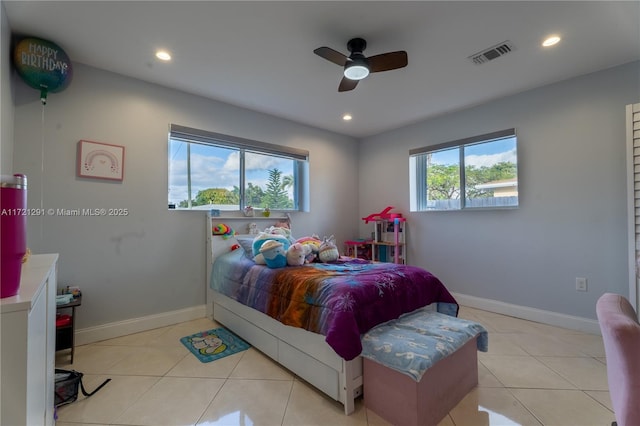 bedroom with ceiling fan, light tile patterned floors, and multiple windows