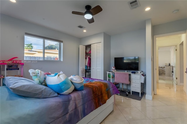 bedroom with ceiling fan, light tile patterned floors, and a closet