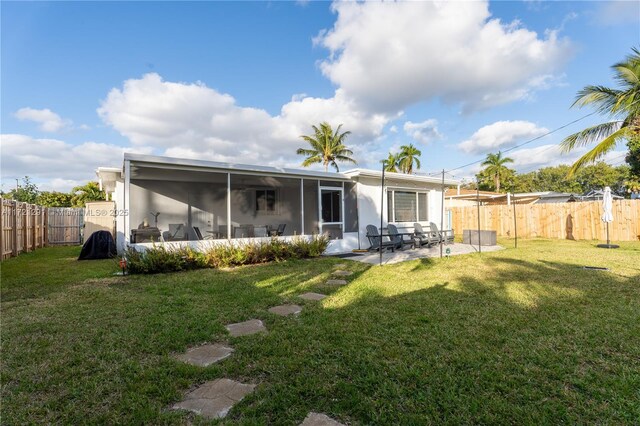 back of house with a lawn, a patio area, and a sunroom