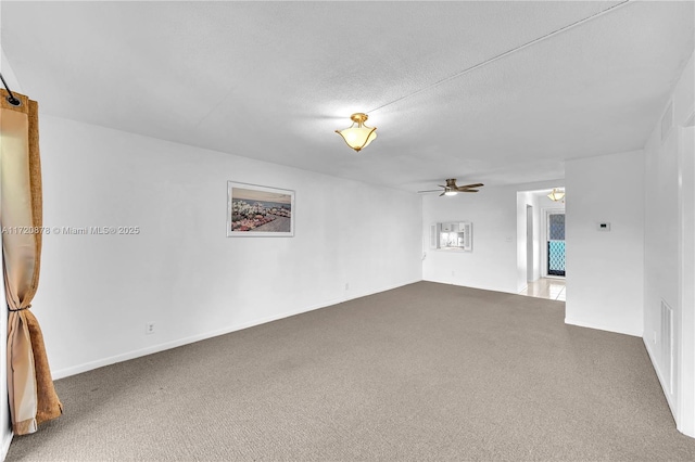 empty room featuring ceiling fan, carpet floors, and a textured ceiling