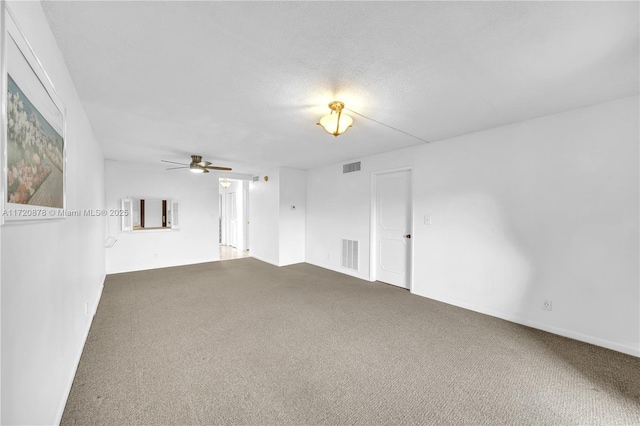 carpeted empty room featuring ceiling fan and a textured ceiling