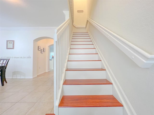 stairway with tile patterned flooring and crown molding