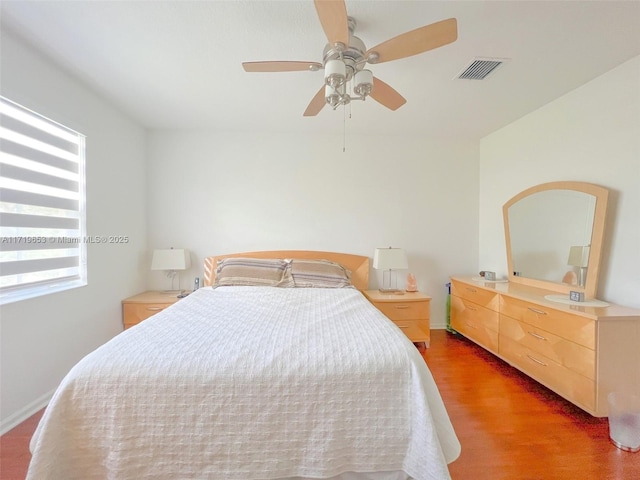 bedroom with ceiling fan and dark wood-type flooring