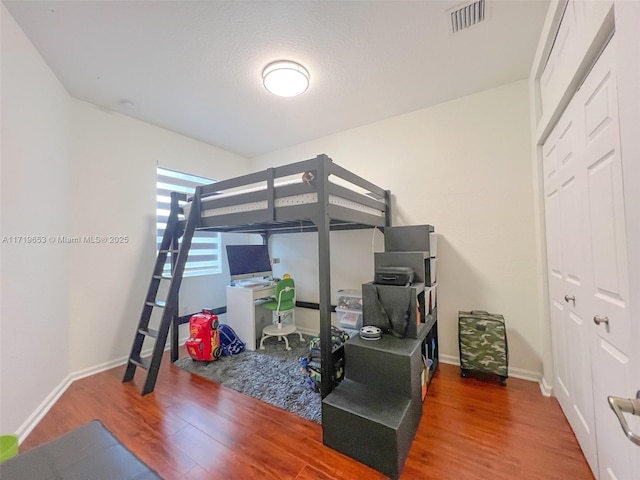 bedroom featuring a textured ceiling and hardwood / wood-style flooring