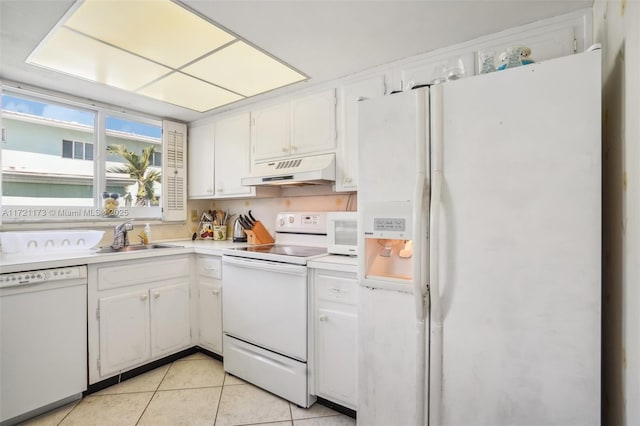 kitchen featuring sink, light tile patterned flooring, premium range hood, white appliances, and white cabinets