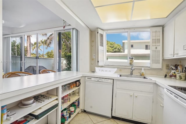 kitchen featuring sink, dishwasher, range, white cabinetry, and light tile patterned flooring