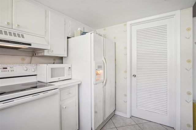 kitchen featuring white appliances, white cabinets, light tile patterned flooring, and range hood