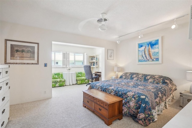 bedroom featuring a textured ceiling, ceiling fan, light carpet, and track lighting