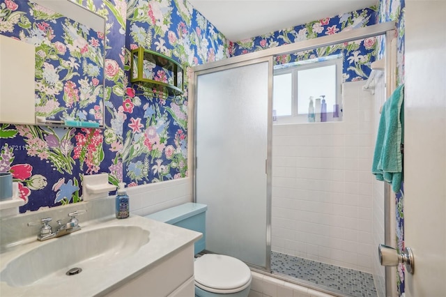 bathroom with vanity, toilet, and a shower with door