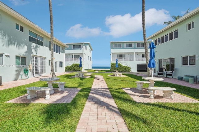 view of property's community with a lawn and a patio