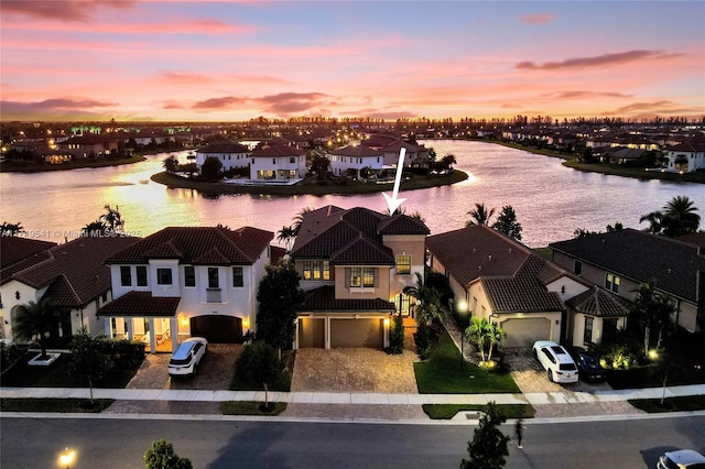 aerial view at dusk featuring a water view