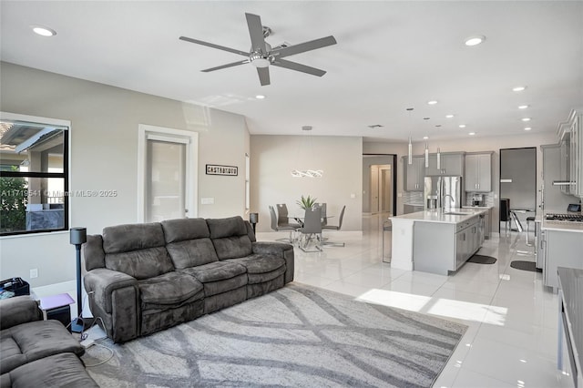 tiled living room featuring ceiling fan and sink