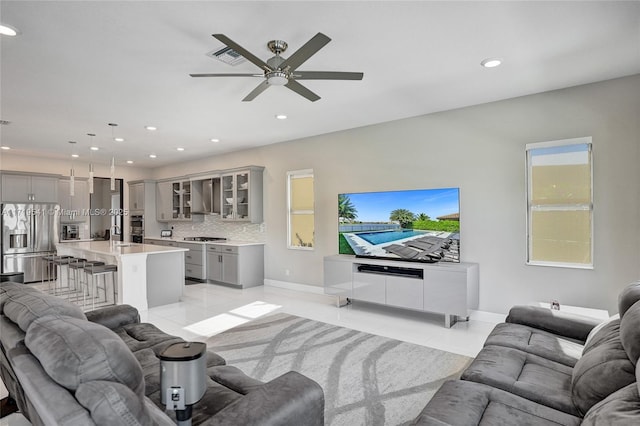 living room with ceiling fan and light tile patterned floors