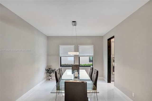 tiled dining room with a chandelier